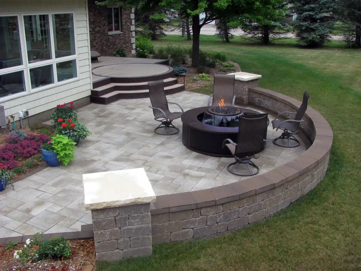 Curved paver patio with metal fire feature and decorative seating wall