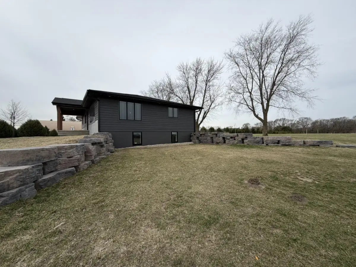 Modern home with large natural outcropping retaining wall