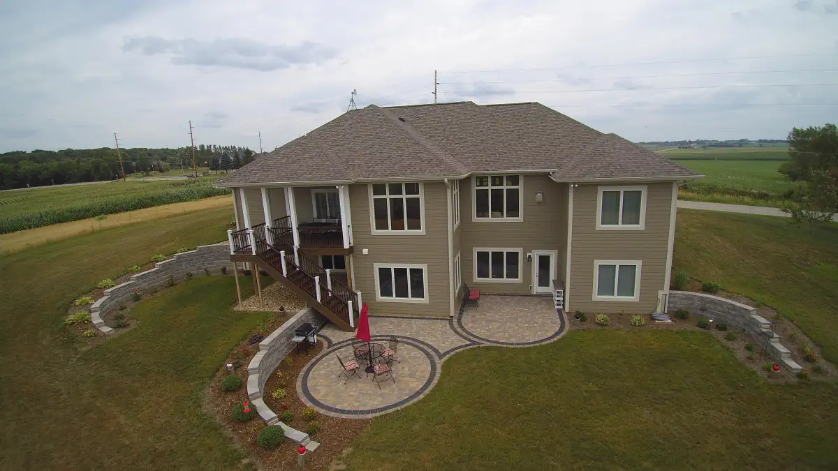 Aerial view of concrete block retaining walls wrapping residential property with circular paver patio